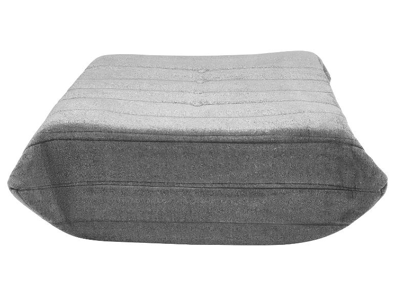 Pouf gris avec boutons et coutures horizontales, vu de côté.