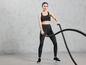 Une femme en tenue de sport utilise une corde à sauter pour s'entraîner.