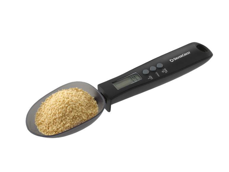 Cuillère de mesure numérique de cuisine avec écran, remplie de couscous.