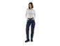 Une femme porte un t-shirt blanc à manches longues et un jean bleu avec des poches supplémentaires.