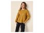 Femme portant un pull tricoté jaune moutarde et un pantalon noir, mains dans les poches