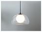 Un luminaire suspendu moderne avec un abat-jour en verre.