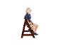 Garçon assis sur une chaise pliante en bois marron, souriant.