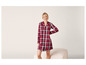 Une femme portant une chemise de nuit rouge à carreaux.
