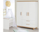 Un lit bébé blanc avec un ciel de lit et une armoire blanche avec des détails en bois.
