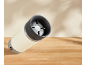 Mug isotherme blanc avec couvercle gris foncé sur une table en bois.