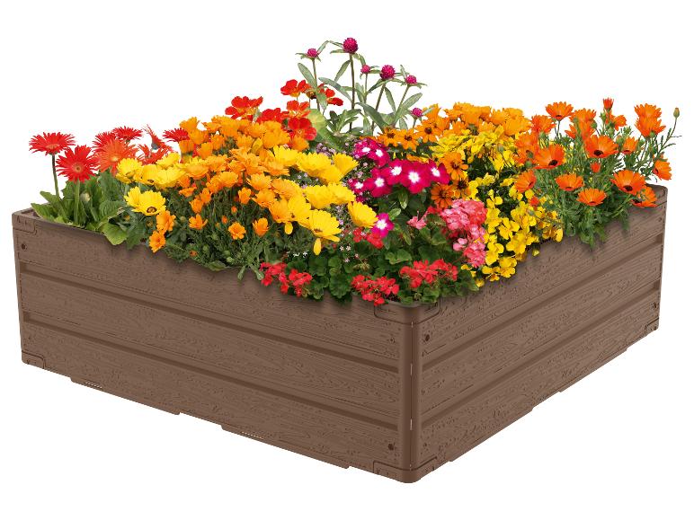 Jardinière en plastique imitation bois avec gerberas et autres fleurs colorées.