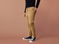 Un homme porte un pantalon beige avec un cordon de serrage et des baskets noires.