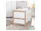 Lit bébé blanc et en bois avec literie dans une chambre d'enfant lumineuse.