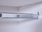 Une tringle à vêtements chromée dans une armoire blanche.