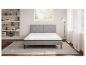 Matelas et sommier gris clair dans une chambre moderne.