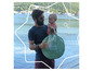 Un homme et un enfant tiennent une tente pop-up Bada Bulle sur la plage au bord de la mer.