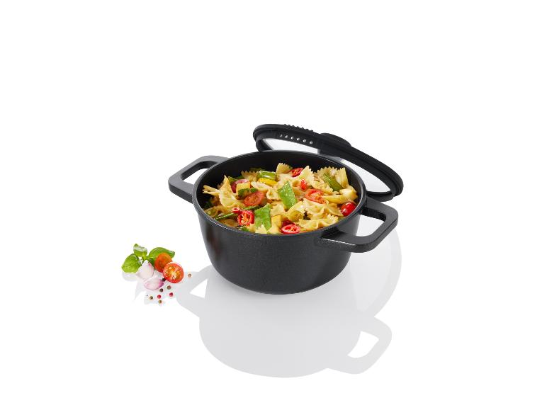 Une casserole noire avec un couvercle, remplie de pâtes et de légumes.