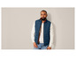 Un homme portant une veste bleue et un t-shirt blanc.