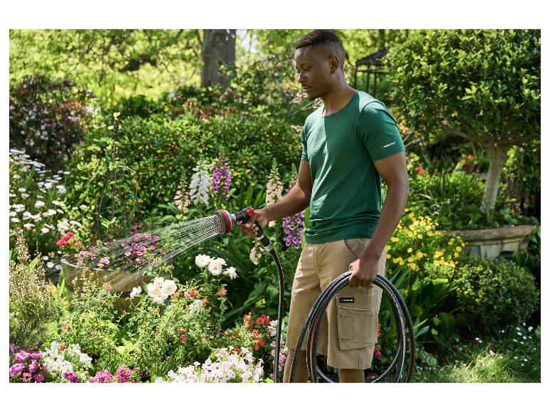 Homme arrosant des fleurs dans un jardin avec un tuyau d'arrosage et un pistolet Parkside.