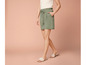Femme portant un pantalon vert avec un cordon et des sandales blanches.