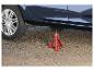 Une voiture surélevée sur un cric rouge.