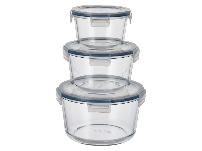 Trois récipients ronds en verre avec couvercles transparents et joints bleus, empilés.