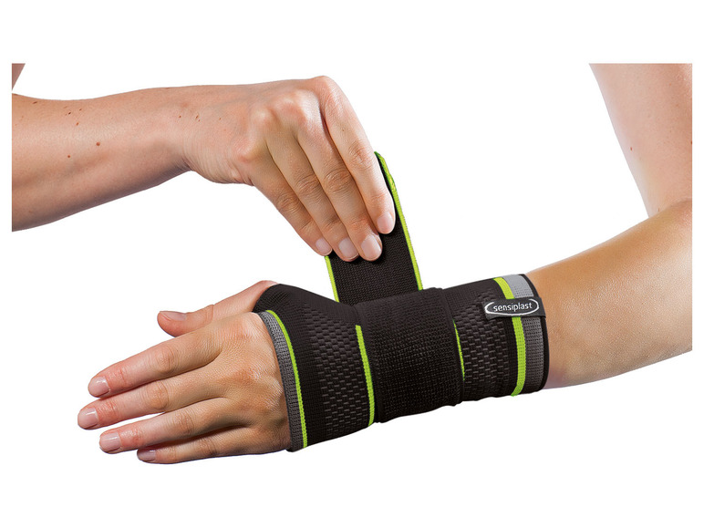 Une attelle de poignet noire Sensiplast avec des accents verts.