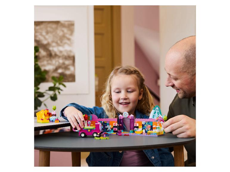 Père et fille souriants jouent avec un ensemble de construction coloré.