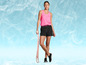 Une femme vêtue d'un débardeur de sport rose, d'un short noir et de baskets noires avec un élastique de résistance rose.