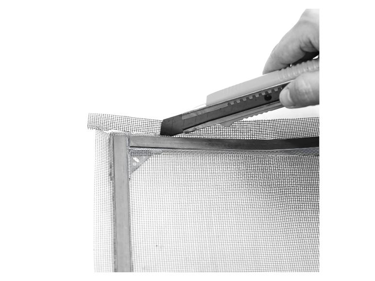 Une main utilisant un couteau pour couper une moustiquaire de fenêtre.