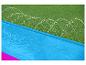Toboggan aquatique bleu et rose sur gazon.