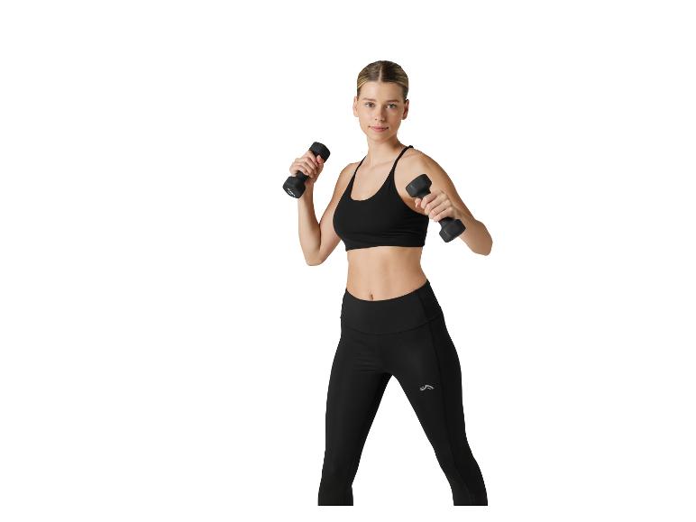 Femme en brassière de sport noire et leggings, s'entraînant avec des haltères noirs