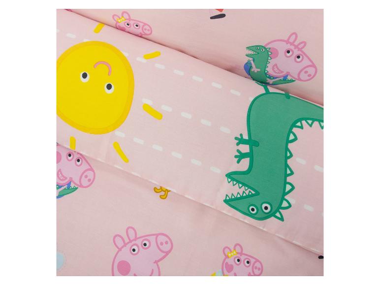 Parure de lit rose avec personnages de dessins animés, soleil et dinosaures.