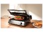 Grill avec un sandwich à l'intérieur et du pain grillé sur une assiette à côté.