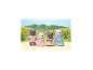 Quatre figurines de chats en peluche habillées, posant sur un patio avec un arrière-plan de collines.