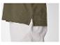 Chemise polo vert olive avec pantalon blanc.