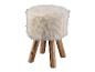 Un pouf en fourrure blanche sur des pieds en bois