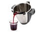 Un liquide rouge est versé d'un bol Thermomix dans un pot en verre.