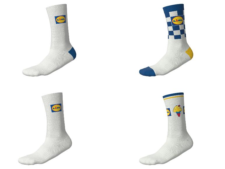 Quatre paires de chaussettes blanches avec divers motifs bleus et jaunes, y compris des carreaux et une glace.