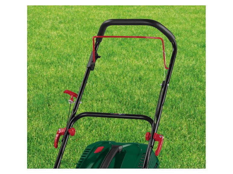 Poignée de tondeuse à gazon avec leviers rouges sur pelouse verte