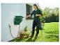 Une femme utilise un enrouleur de tuyau d'arrosage Parkside pour arroser des plantes.