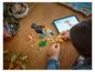 Un enfant construit un perroquet LEGO Creator 3-en-1, suivant les instructions sur une tablette.