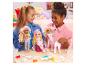 Deux filles jouent avec des poupées Rainbow High et des accessoires.
