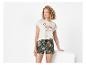 T-shirt blanc à flamant rose et shorts fleuris tropicaux.