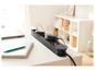 Une multiprise noire avec des prises sur un bureau blanc.