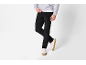 Homme en pantalon de velours côtelé noir, sweat-shirt gris et baskets blanches.
