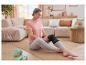 Femme dans un salon sur un tapis de gym avec une genouillère Sensiplast.