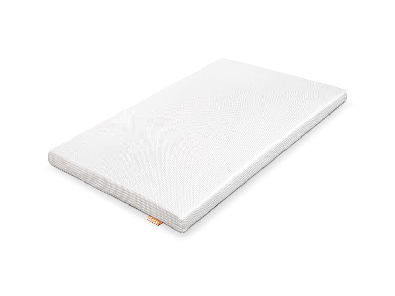 Matelas blanc avec surface texturée et étiquette orange sur le côté.