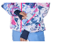 Femme insérant une carte dans la poche de la manche d'une veste de ski colorée.