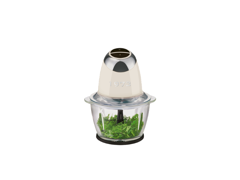 Hachoir couleur crème avec base en verre remplie d'herbes fraîches.