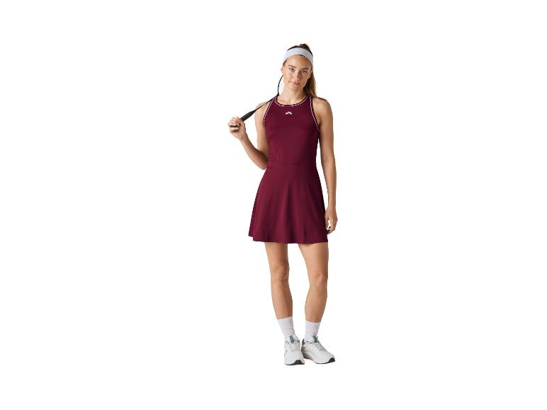 Femme en robe de sport bordeaux avec une raquette de badminton.