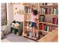 Bibliothèque en bois, range-livres vert, petite fille rangeant des livres.