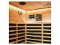 Intérieur d'un sauna en bois avec panneau de commande, haut-parleur et bancs à lattes.