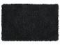 Tapis shaggy noir avec une texture douce.